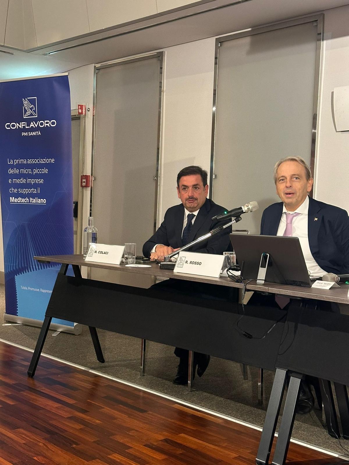 Un momento del confronto al tavolo, accanto al roll-up associativo.